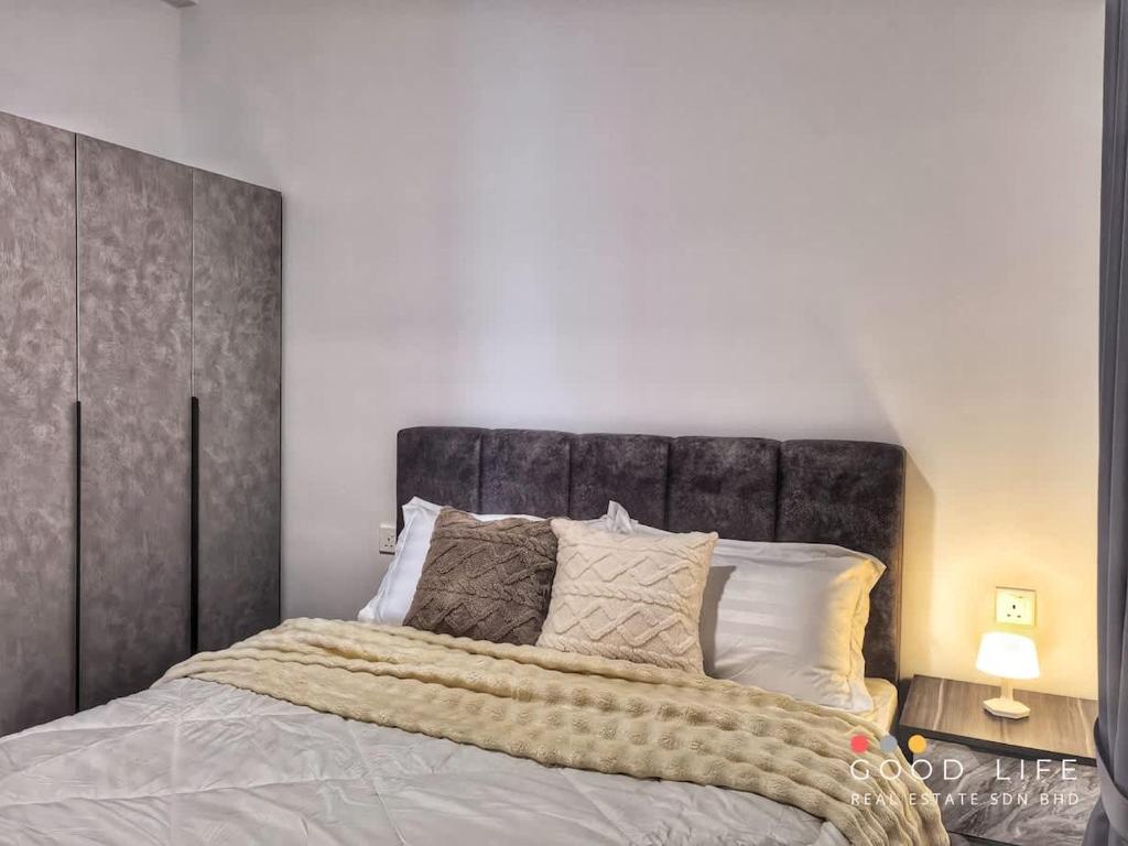 a bedroom with a large bed with a gray headboard at R&F Princess Cove Double Bed Room Shared Common Space in Johor Bahru