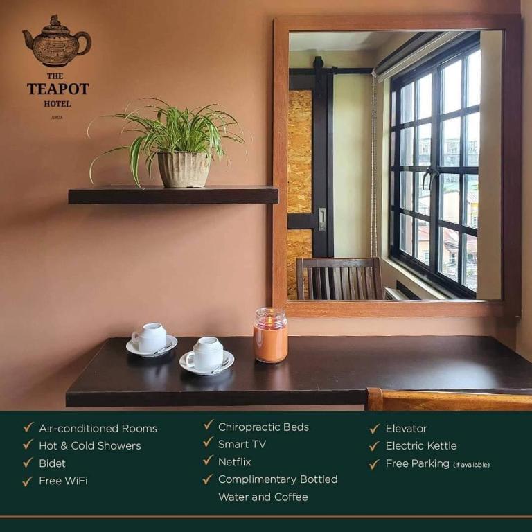 ein Zimmer mit einem Tisch, einem Spiegel und einem Fenster in der Unterkunft The Teapot Hotel in Naga