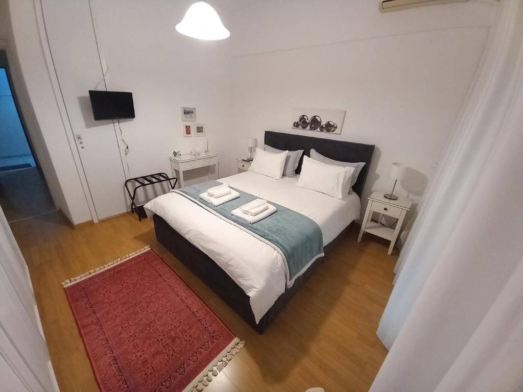 a bedroom with a large white bed and a red rug at Απολαύστε τη διαμονή σας στις Σέρρες in Serres