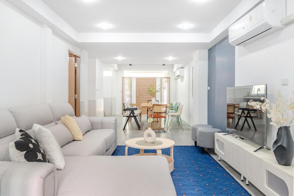 a living room with a white couch and a table at Haus Ekkamai 2 in Khlong Toei