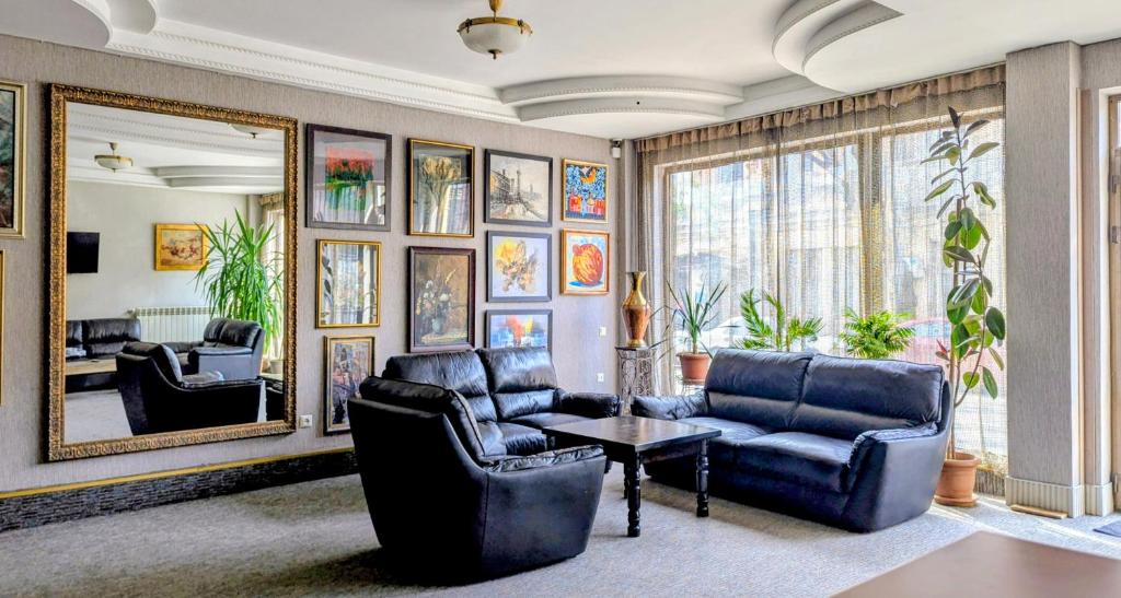 a living room with couches and a table and a mirror at The Rogashome in Tbilisi City