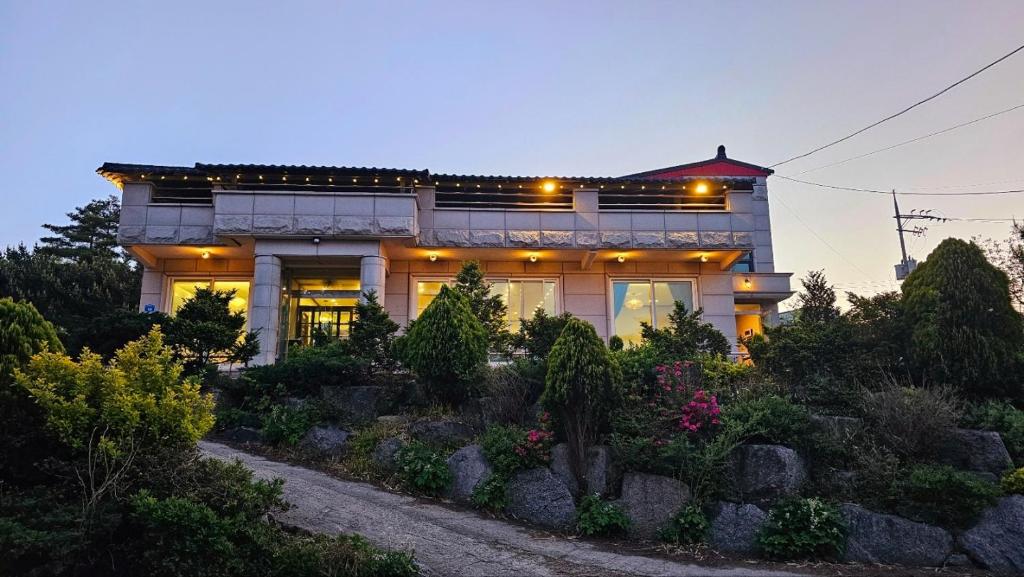 a house with a garden in front of it at 와바다펜션 속초고성 독채펜션12인 삼포해수욕장1분 바베큐불멍 in Goseong