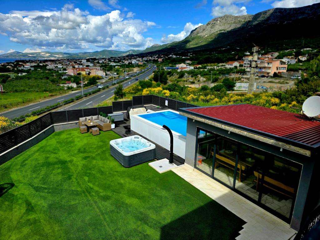 a house with a green yard with a swimming pool at Villa Black&White in Kastel Sucurac