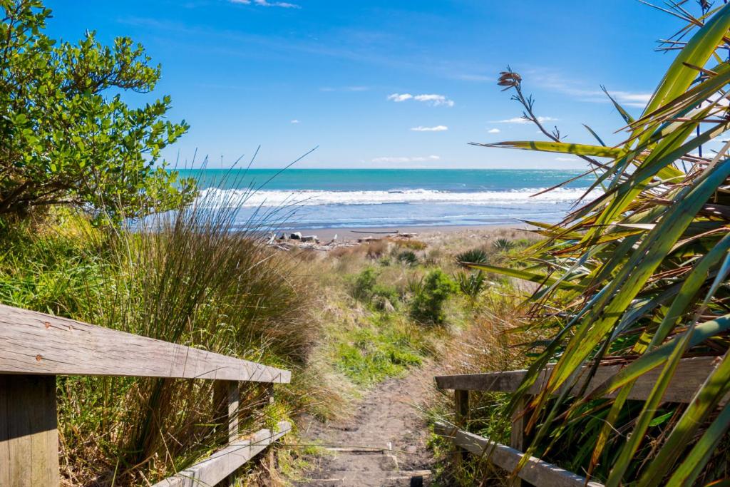 a path to the beach with the ocean in the background at Fabulous In Fitzroy - seconds to Fitzroy Beach in New Plymouth