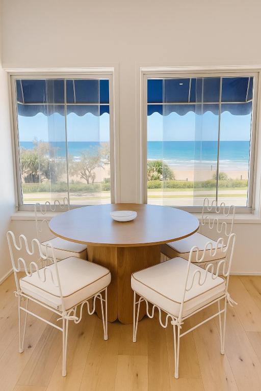 アレクサンドラ・ヘッドランドにあるBeachfront Penthouse With Uninterrupted Ocean Viewsのテーブルと椅子と窓のあるダイニングルーム