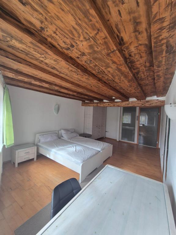 a bedroom with a bed and a wooden ceiling at City Rooms Steyr in Steyr