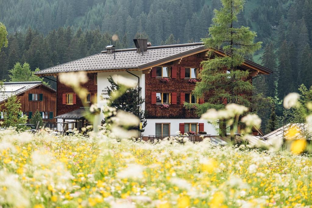 a house in the middle of a field of flowers at Haus Braunarl in Lech am Arlberg
