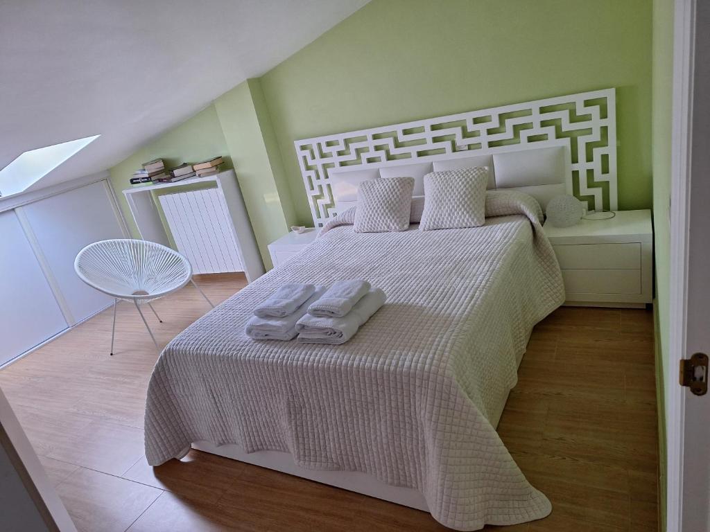 ein Schlafzimmer mit einem weißen Bett mit Handtüchern darauf in der Unterkunft Casa Rucueva in Liendo