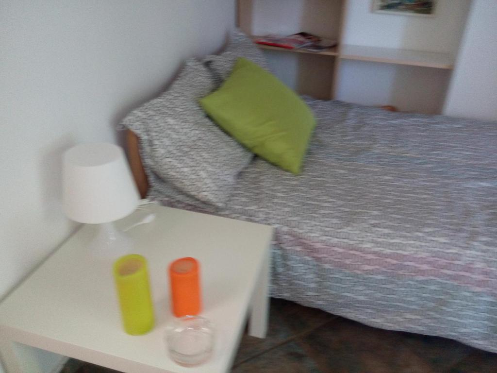 アイオス・コンスタンティノス・フティオティダにあるAnastasia - Efthimios Apartmentsのベッドルーム1室(ベッド1台、テーブル、ナイトスタンド付)