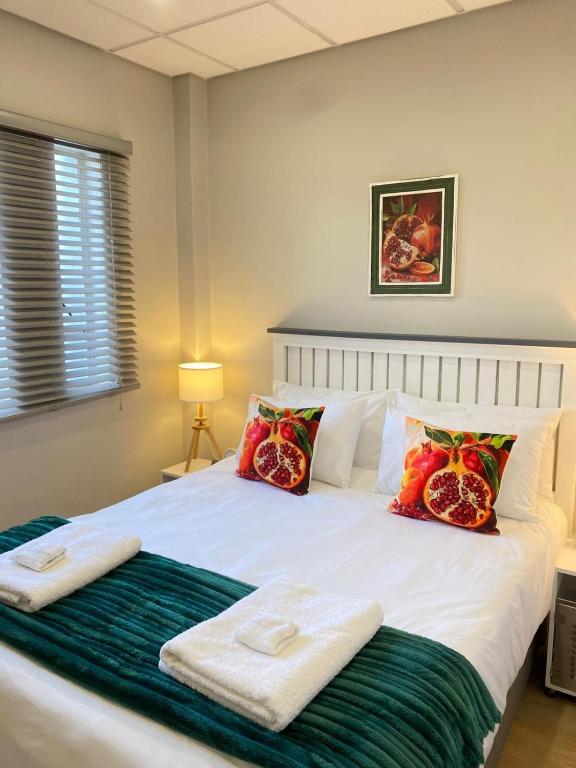 a bedroom with a bed with towels on it at Granaat Pit - Paarl - Self Catering Apartment in Paarl