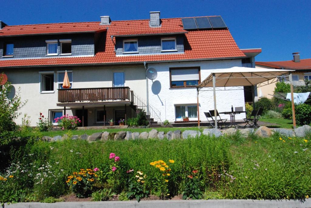 a house with a garden and an umbrella at Ferienwohnung Gartenstrasse in Gersfeld