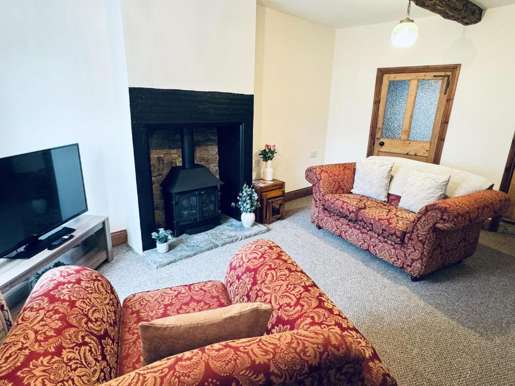a living room with two couches and a fire place at Kirkgate Cottage - 2 Bedrooms - Sleeps 4 in Cockermouth