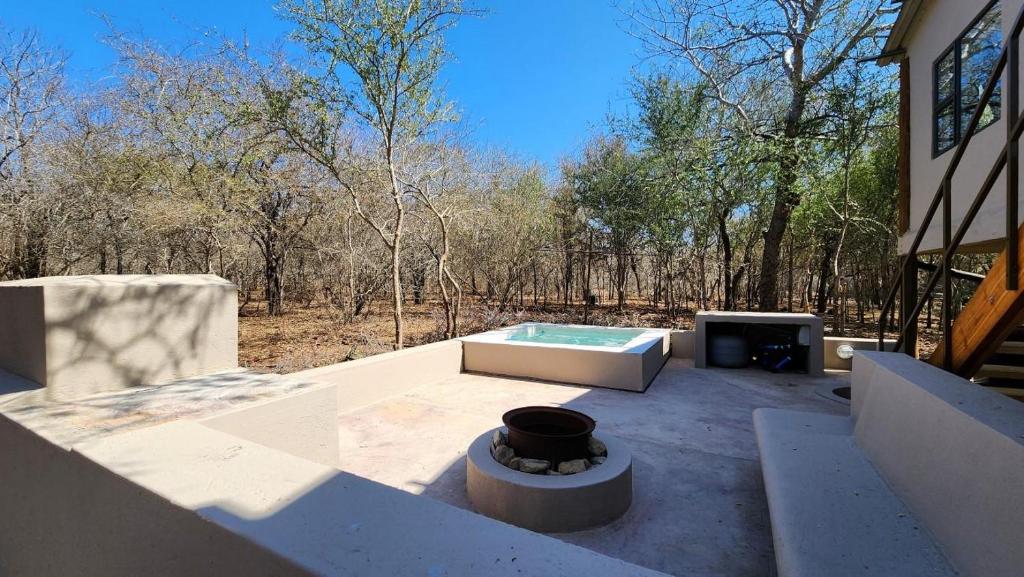 a patio with a hot tub and a fireplace at Erdvarkie at Kruger, Marloth Park in Marloth Park