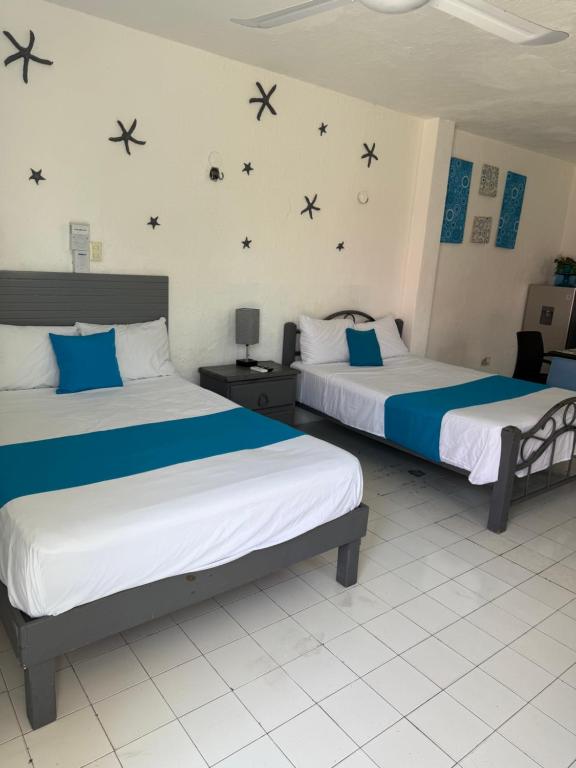 zwei Betten in einem Zimmer mit Sternen an der Wand in der Unterkunft Casa San Miguel 1 in Cozumel
