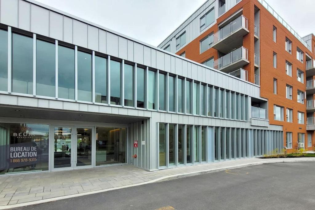 ein externer Blick auf ein Gebäude mit einem Parkplatz in der Unterkunft Corporate Stays Blum 2 Bedrooms in Brossard
