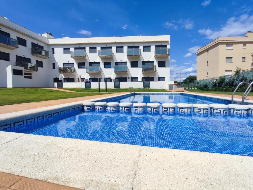 a swimming pool with stools in front of a building at Mediterranean Way - Miami Beach in Miami Platja