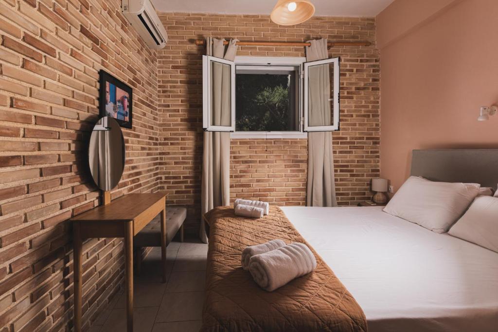 a bedroom with a bed and a brick wall at Artemis Vassilikos in Vasilikos