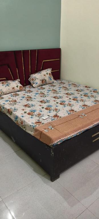 a bed in a room with a flowery comforter at Yamuna Kunj Homestay in Govardhan