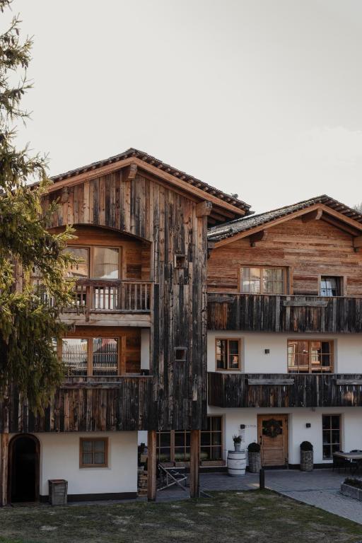 an apartment building with wooden balconies and windows at Sportony Mountain Lodges in La Villa