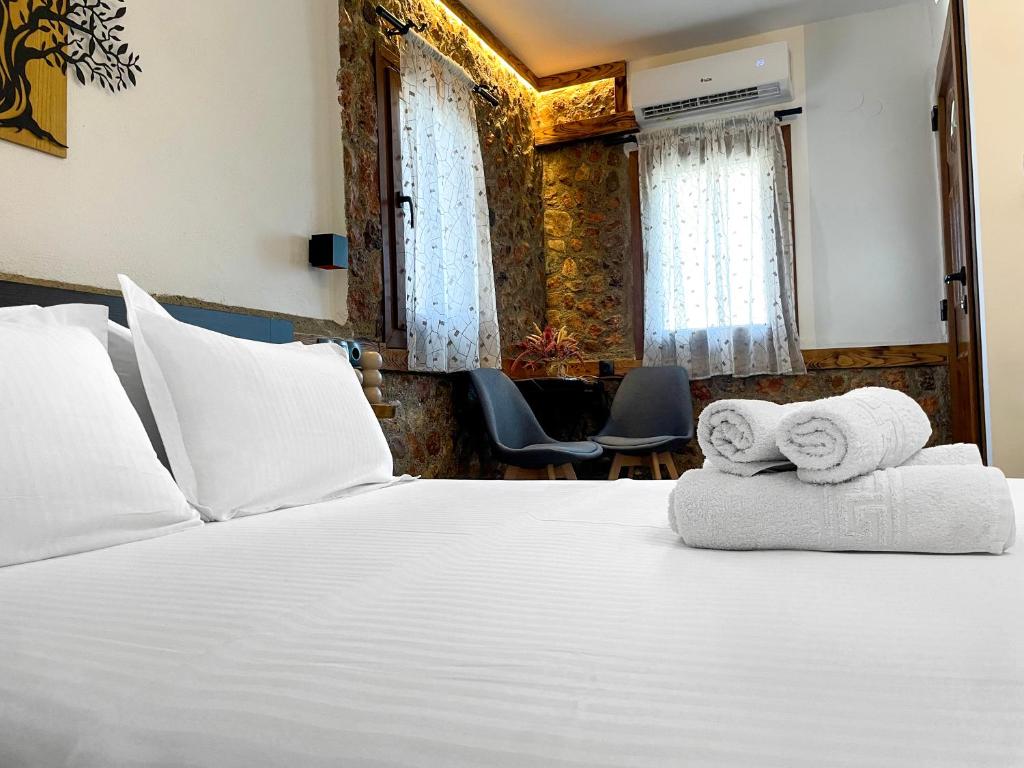 a bedroom with a large white bed with towels on it at Archontiko Kantilis in Díon