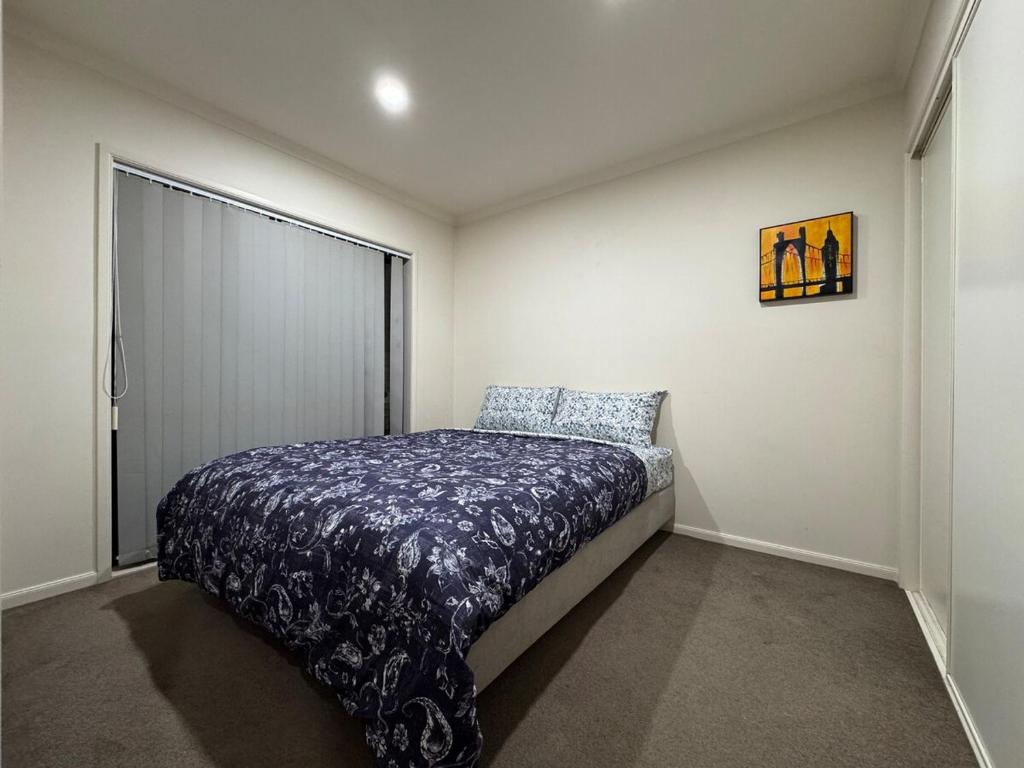 a bedroom with a bed in the corner of a room at Relaxing 3BR Home by Wattle Downs Reserve in Auckland
