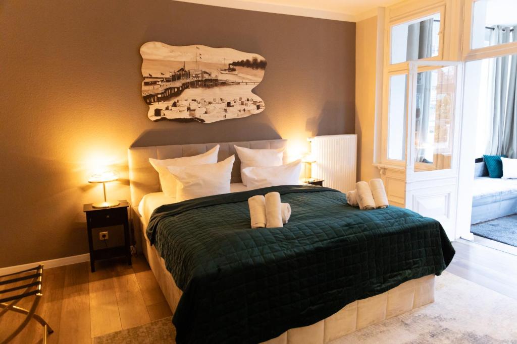 a bedroom with a bed with a green comforter at Hotel Garni BALTICpetite in Heringsdorf