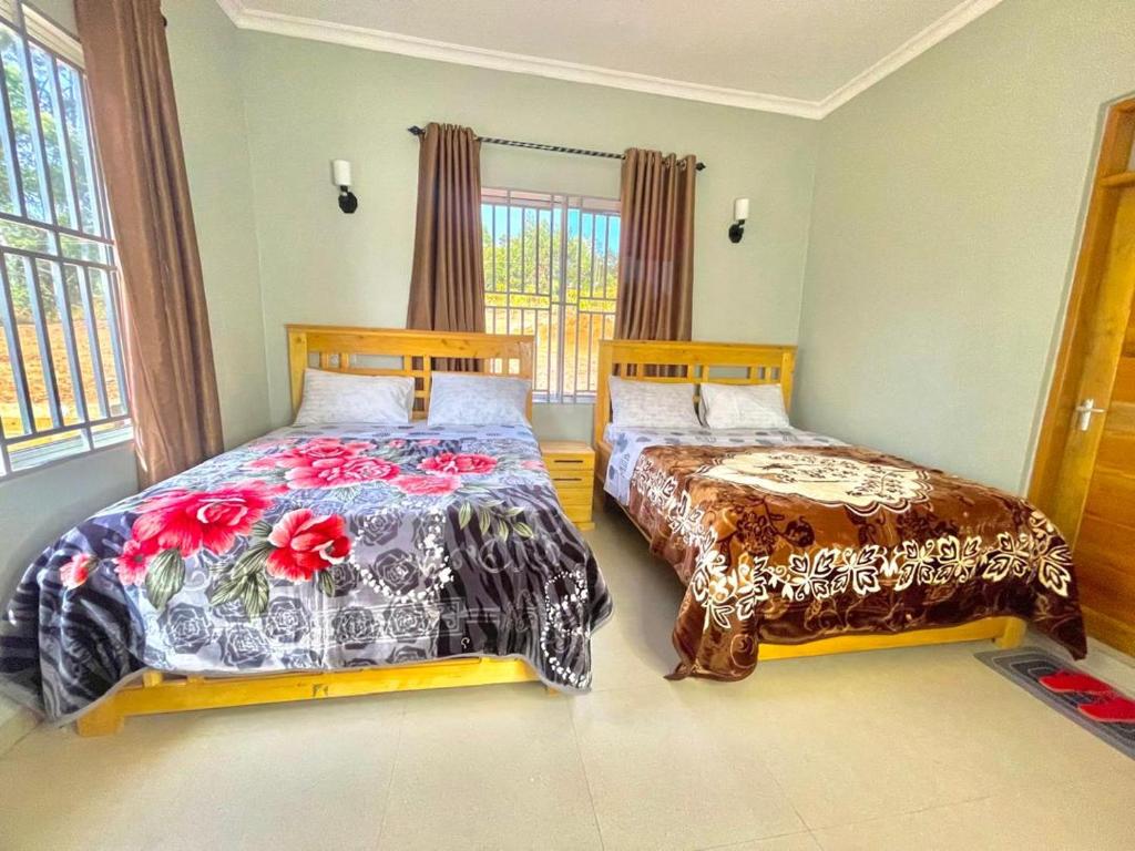 a bedroom with two beds and a window at Emao Lodge 