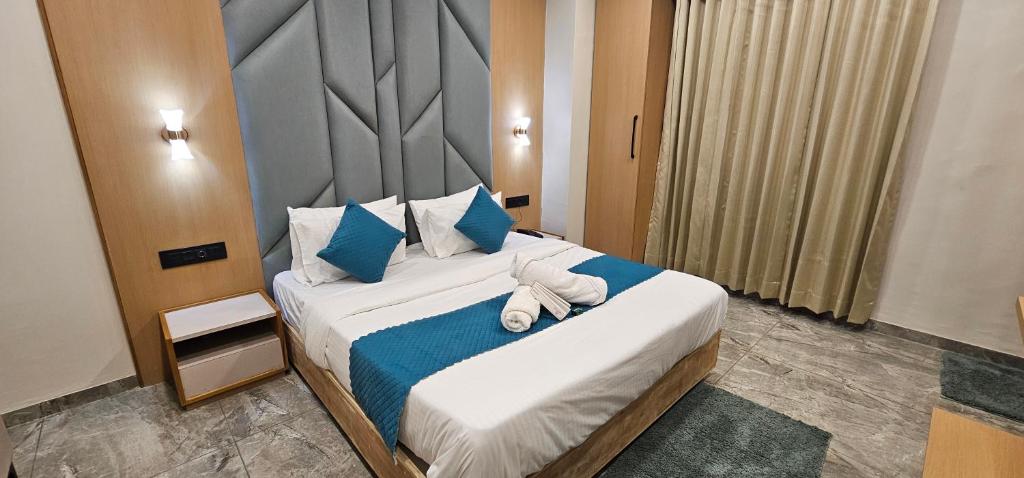 a bedroom with a large bed with towels on it at Hotel Earth Orbit in Gandhinagar