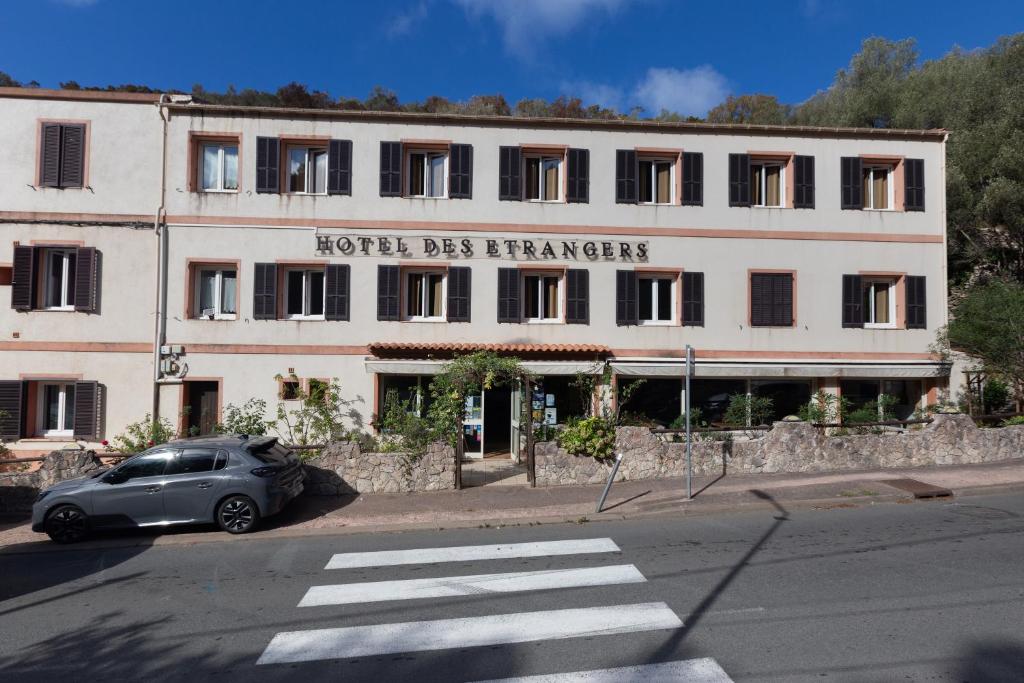 een auto geparkeerd voor een gebouw bij Hotel des Etrangers in Bonifacio