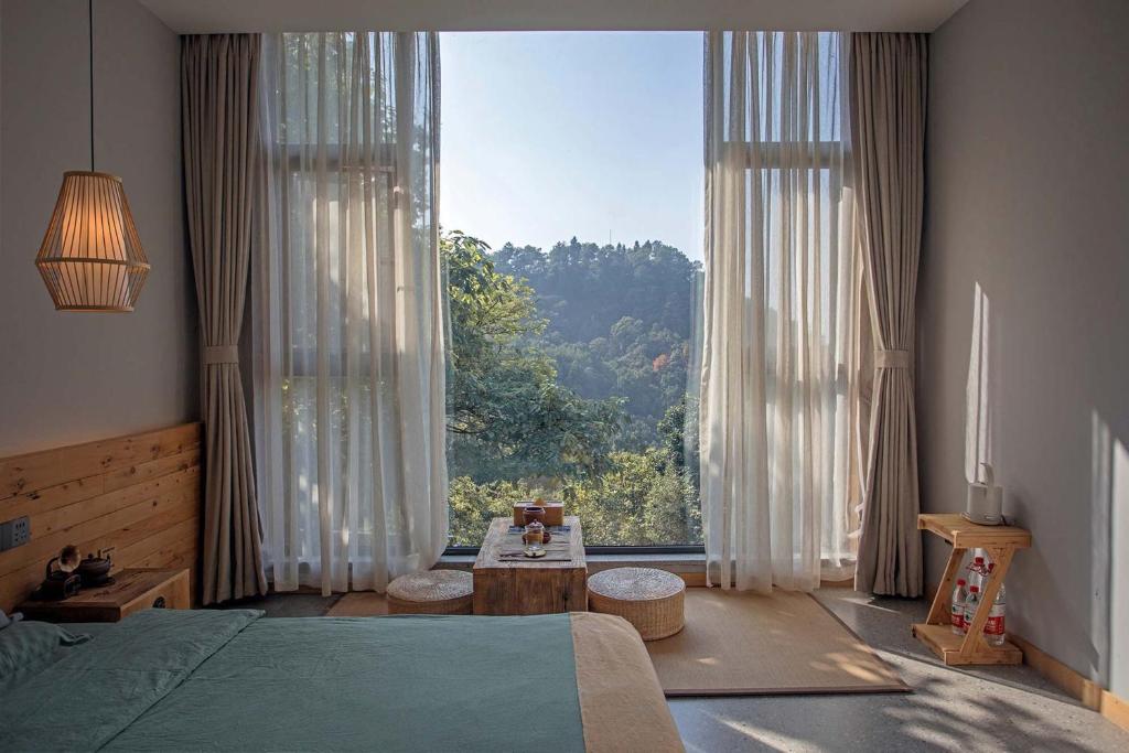 a bedroom with a bed and a large window at Shan Jue Xing She in Nan'an