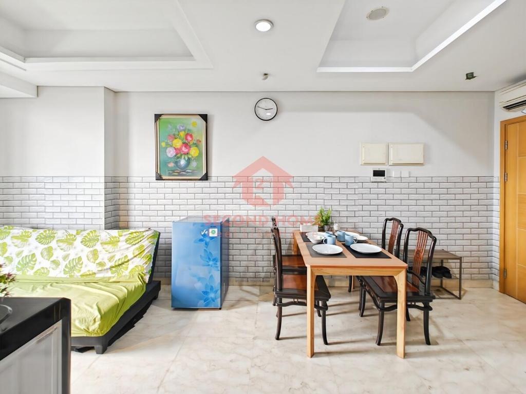 a living room with a table and a couch at Strategic 2BR Capitol Apt Pool, Gym, Wi-Fi in Jakarta