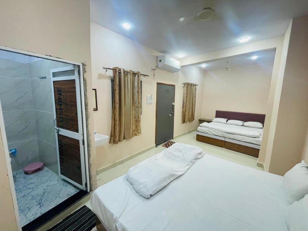 Un dormitorio con una cama y una ducha de cristal. en Shree Shivay Residency, en Ujjain