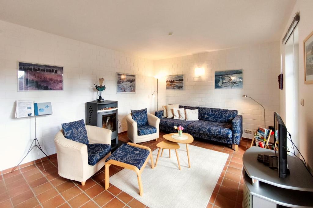 a living room with a couch and chairs and a tv at Ferienwohnung Merkel in Koserow