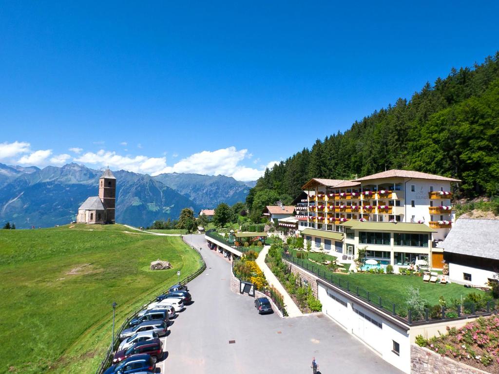 a hotel with cars parked in a parking lot at Hotel Sulfner in Avelengo