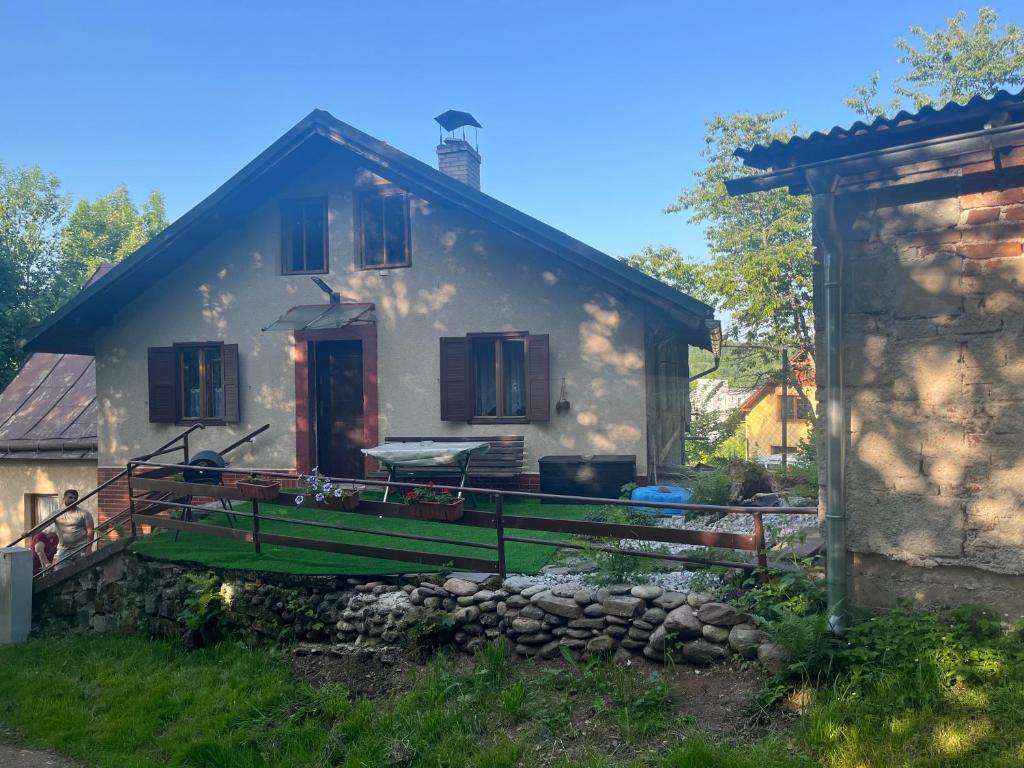 a white house with a green fence in front of it at Chalupa pod lesem in Trutnov