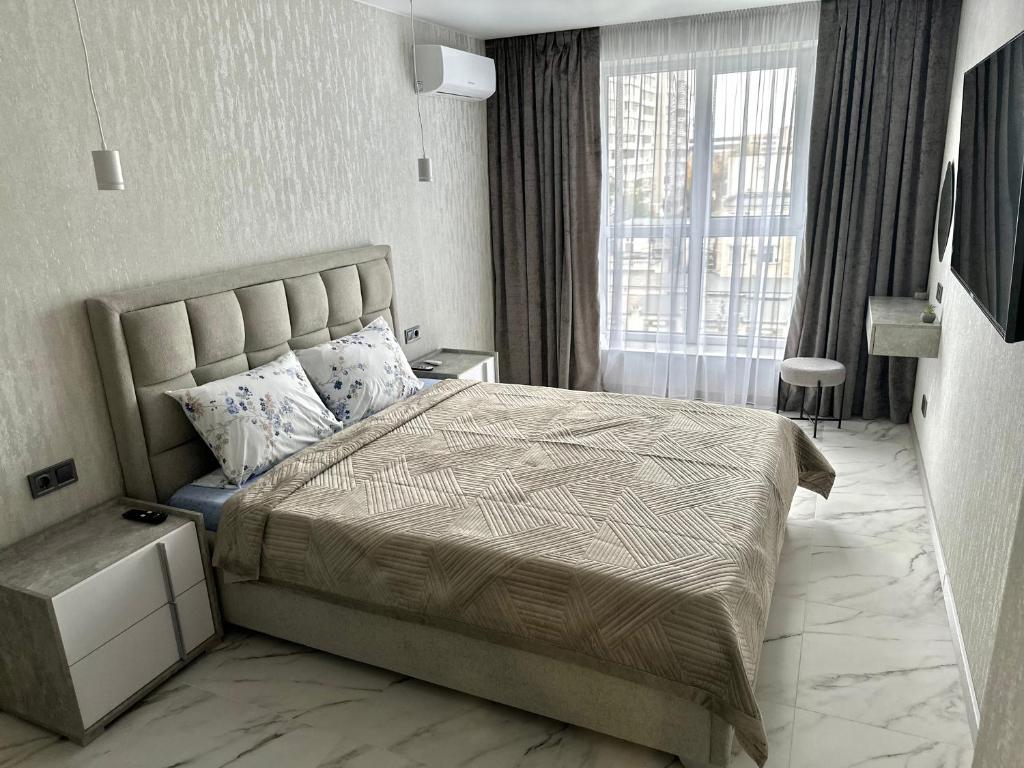 a bedroom with a large bed and a large window at 1 room Ridnyi Dim Apartment in Cherkasy