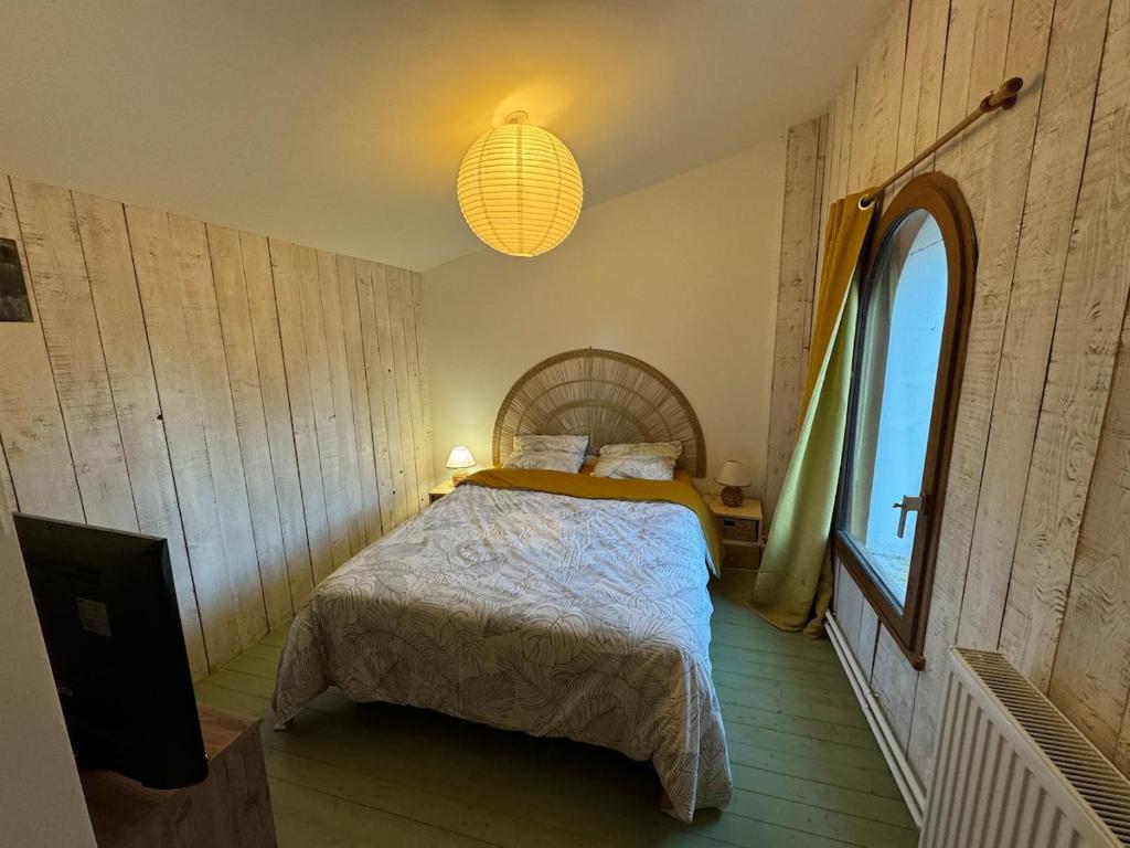 een slaapkamer met een bed en een groot raam bij Gîte du Séquoia - Paisible maison de campagne in Vallet