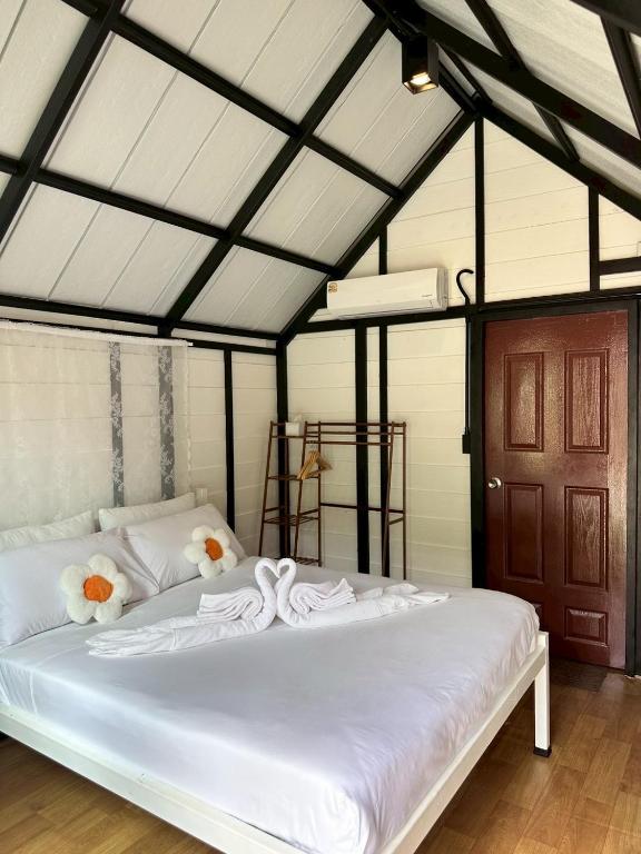 a bedroom with a white bed with flowers on it at Lantamangrove in Ko Lanta