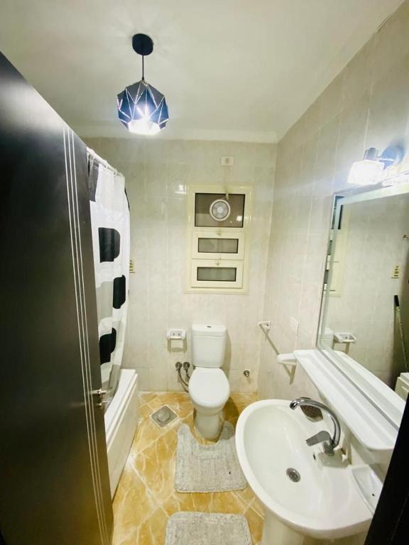 a bathroom with a white toilet and a sink at شقه المتحف in Ghaţāţī