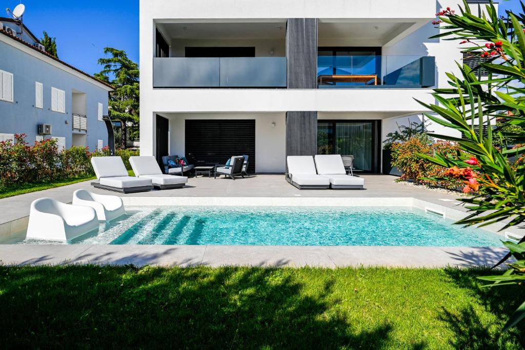 una casa con piscina di fronte a una casa di Chesa Blue Apartment a Rovigno (Rovinj)