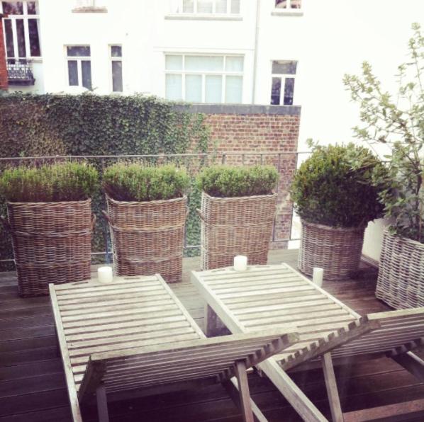 two wooden tables and chairs on a patio with plants at Maison Flagey Brussels in Brussels