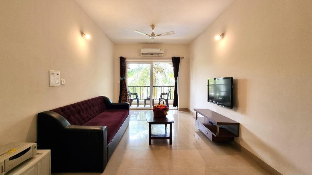 a living room with a couch and a tv at Goa Chillout Apartment - 1BHK, Baga in Baga