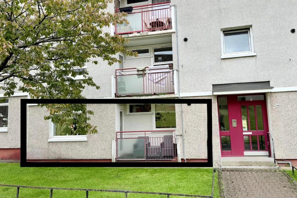 2 Bedroom Apartment - Sleeps 4 Free Parking Wifi في Pollokshaws: مبنى ذو باب وردي وساحة عشبية