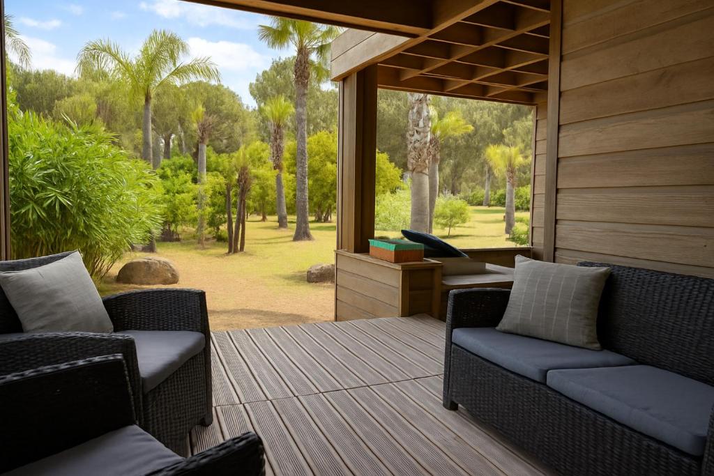 eine Veranda mit Korbstühlen und einem Tisch mit Aussicht in der Unterkunft Pineto, villa 3 chambres au coeur de la pinède in Biguglia