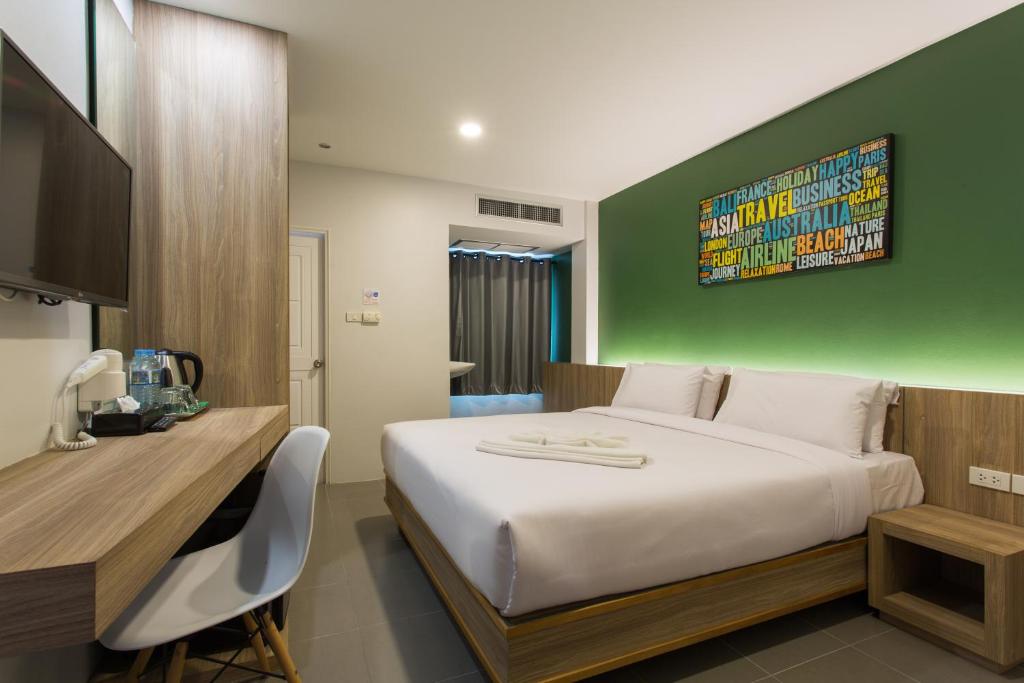 a bedroom with a large bed and a green wall at City Hotel Krabi in Krabi town