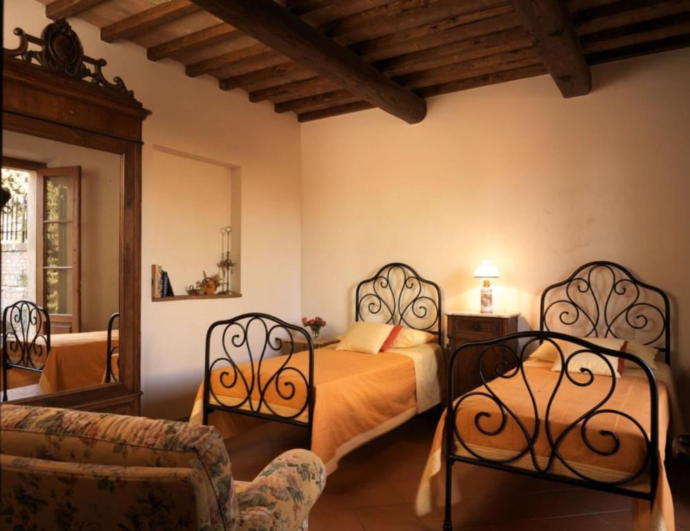 una camera con due letti e un divano di Villa Podere la Tesa a San Gimignano