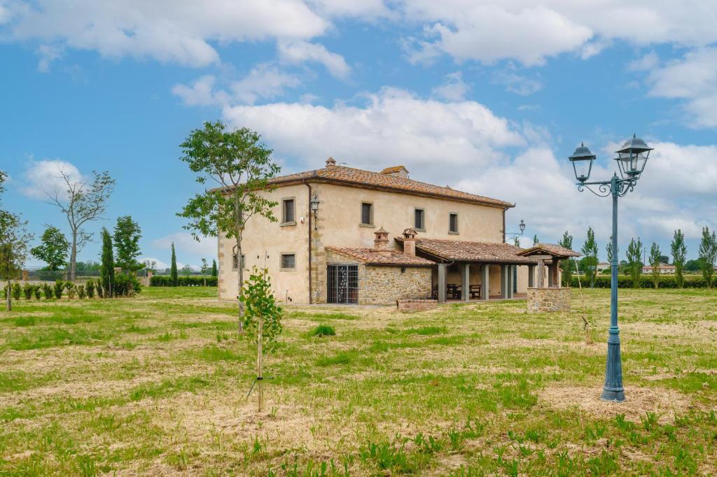 コルトーナにあるAgriturismo Podere Ponticelli - Villa con vista su Cortonaの街灯のある野原にある古い家