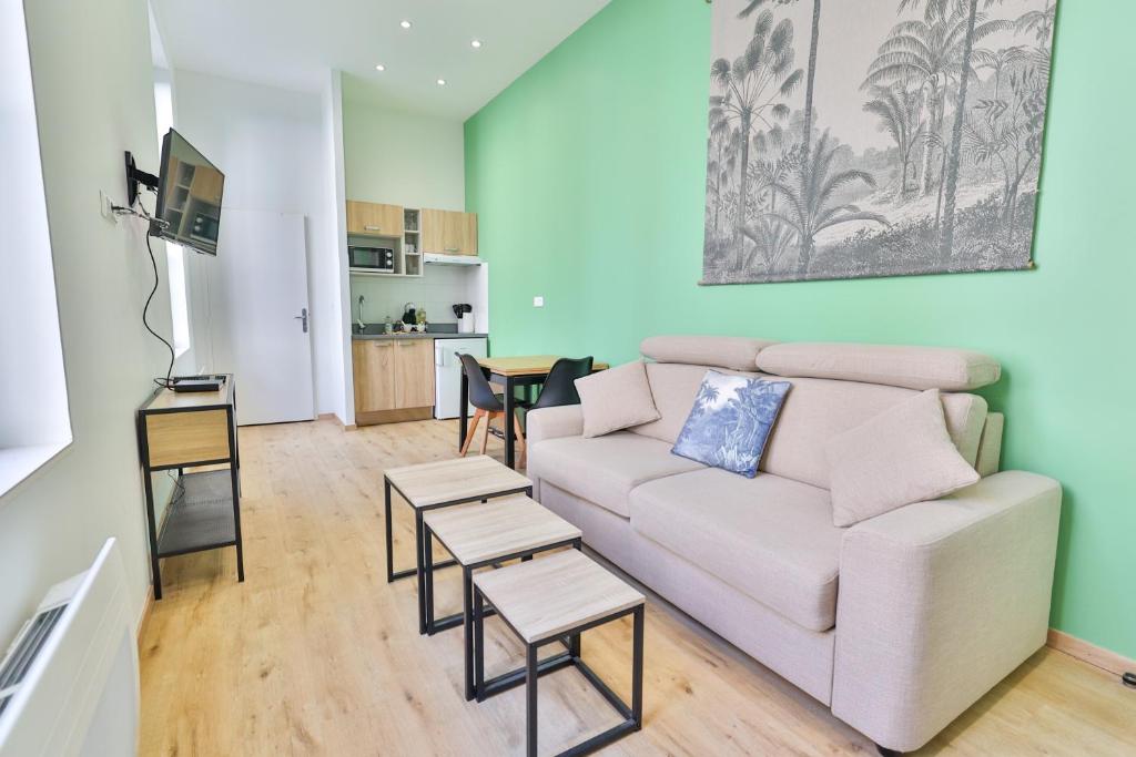 un salon avec un canapé et une table dans l'établissement Le Saint Colette #Parking privé et sécurisé, à Cognac