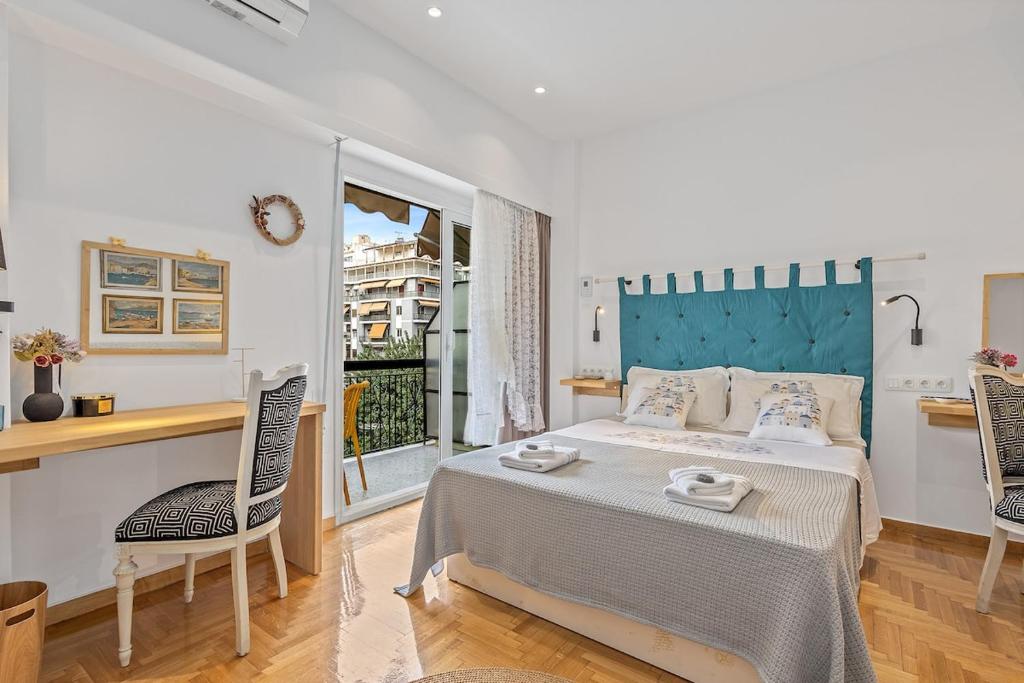ein Schlafzimmer mit einem Bett, einem Tisch und Stühlen in der Unterkunft h2h Kalypso #Luxury, in 5' Port, in 1'metro, Airport, Athens smART, hi-tec in Piräus