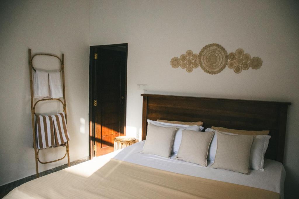 a bedroom with a large bed with white pillows at Casa Sinabowewa in Ahangama